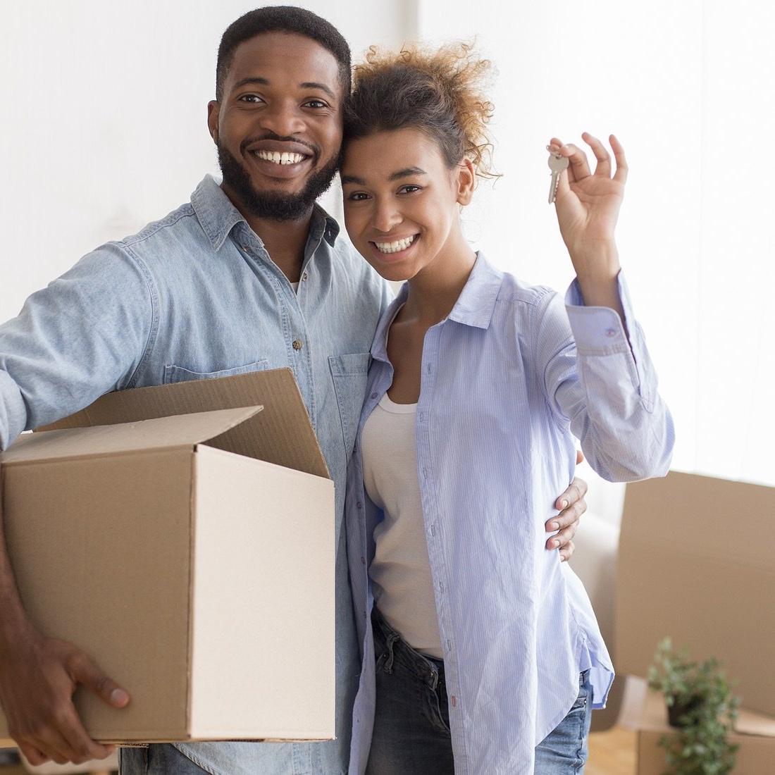 Couple with house key and moving box.